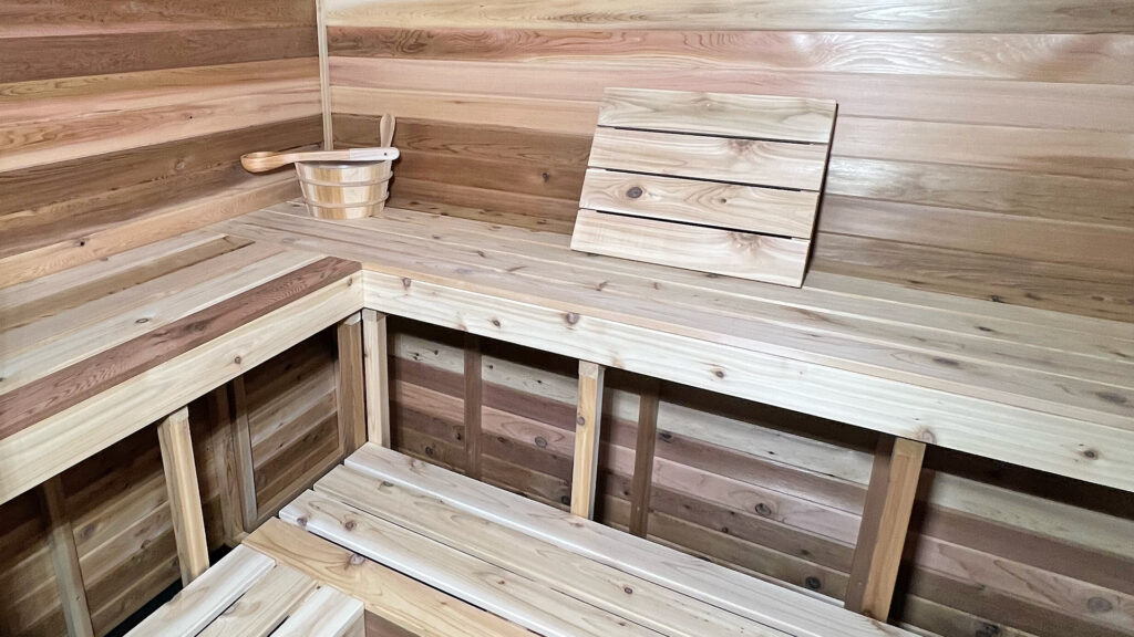 Upper L-shaped cedar bench with a backrest in a 4-5 person home sauna built by Sauna Craft
