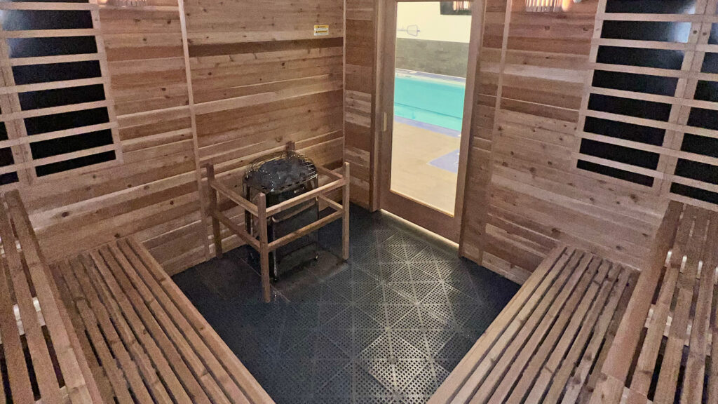 Sauna heater between two long cedar benches in the Colts practice facility sauna built by Sauna Craft