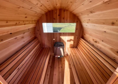 Inside an outdoor sauna built by Sauna Craft: cedar benches, electric heater and window