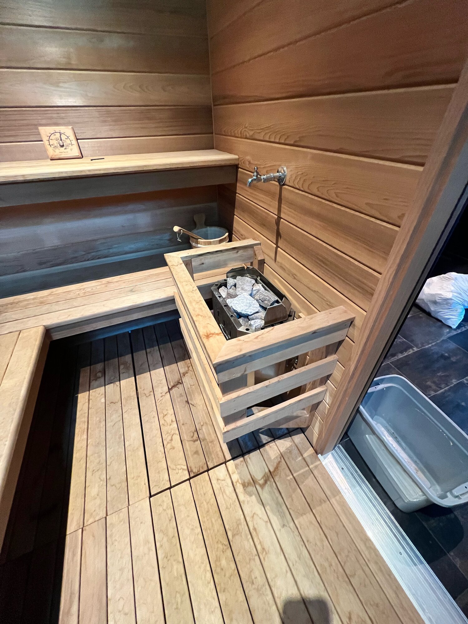 Before: compact wall-style heater in custom builtin sauna