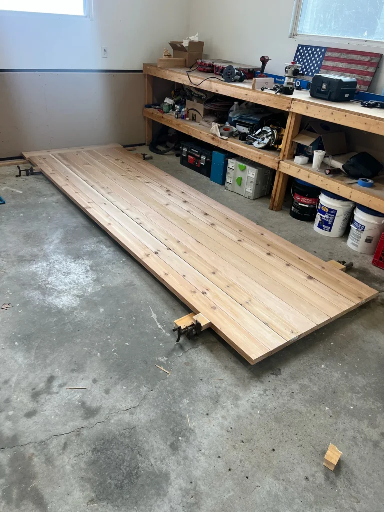 Building a custom trailer sauna: cedar end-wall panel glued and clamped in the Sauna Craft shop
