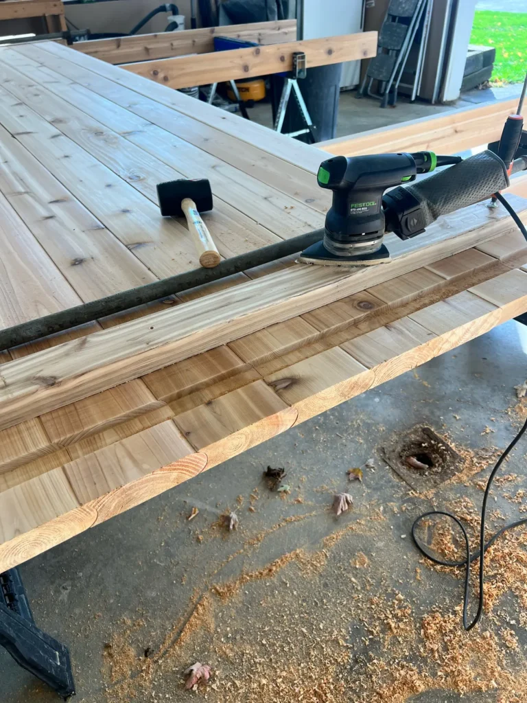 Building a custom trailer sauna: sanding the cedar end wall with a Festool sander