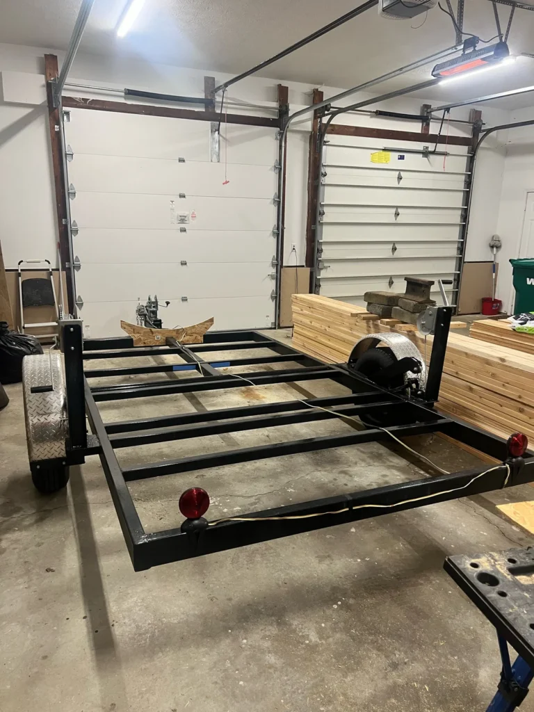 Building a custom trailer sauna: the bare black trailer frame in the Sauna Craft shop